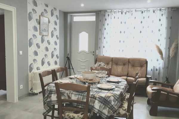 Côté salon : canapés et télé sur meuble à gauche de la photo.