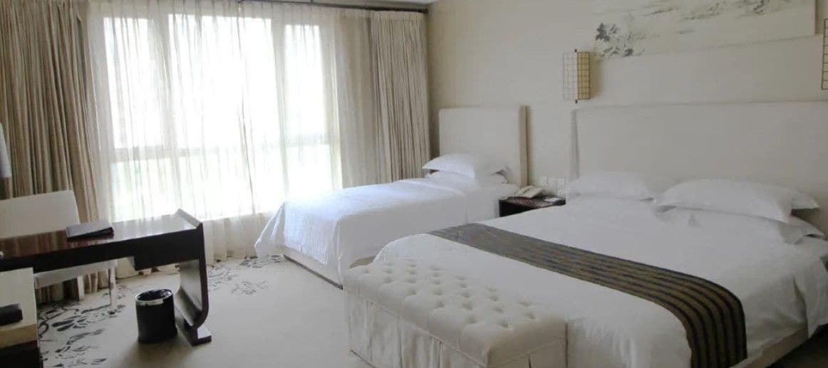 Una habitación de hotel con dos camas, un escritorio y una silla.