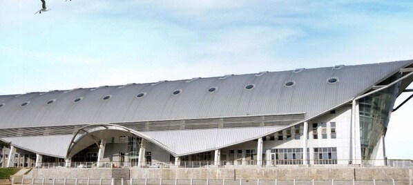 Un bâtiment moderne doté d’un toit incurvé et de grandes fenêtres.