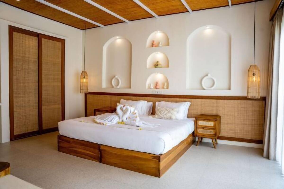 A bedroom with a wooden bed, a nightstand, a wall-mounted shelf with decorative items, and a traditional sliding door.