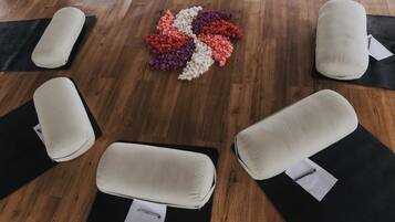 A room with four massage chairs on black mats, arranged in a square pattern on a wooden floor.