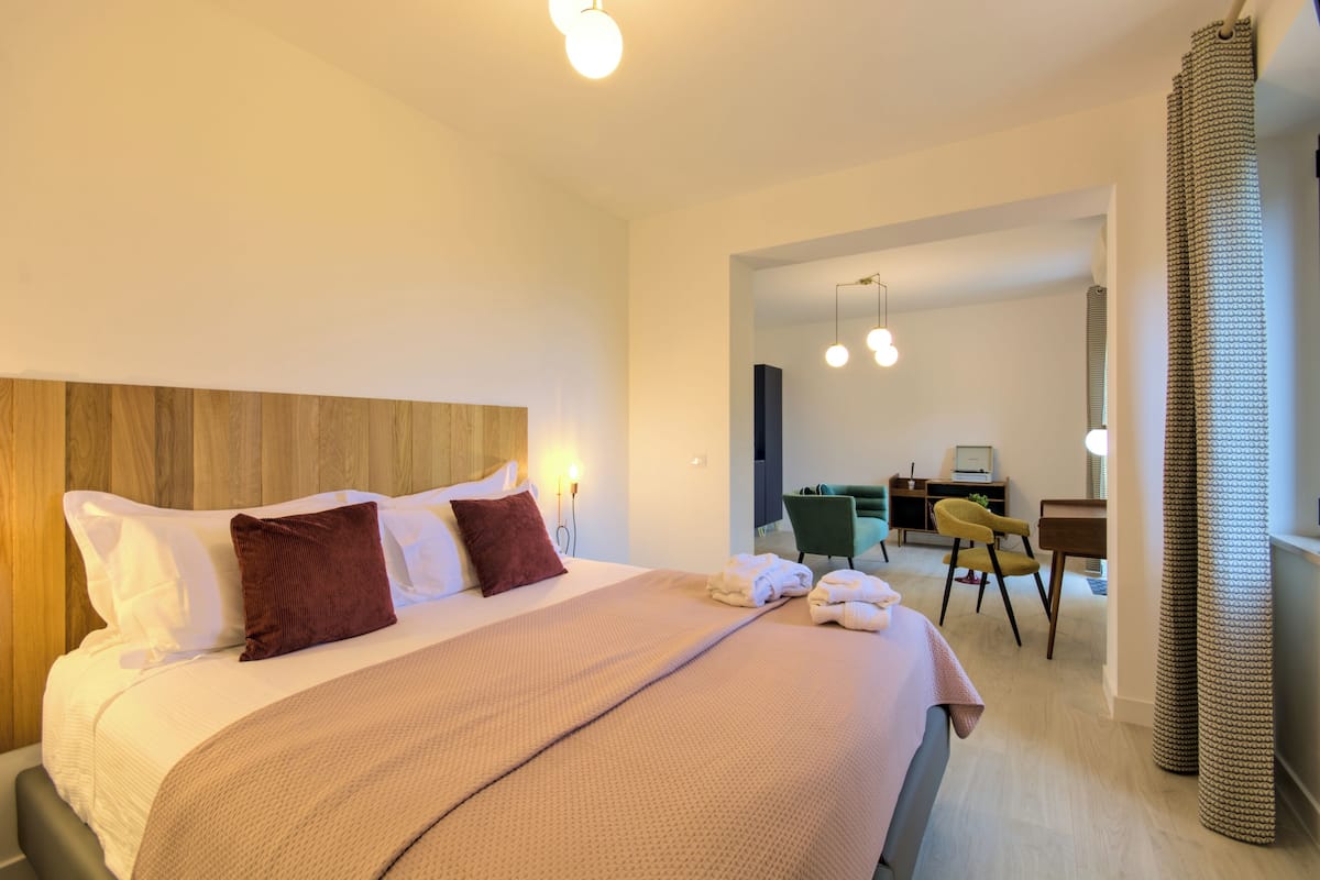 Una habitación de hotel moderna con una cama grande, un escritorio y una silla.