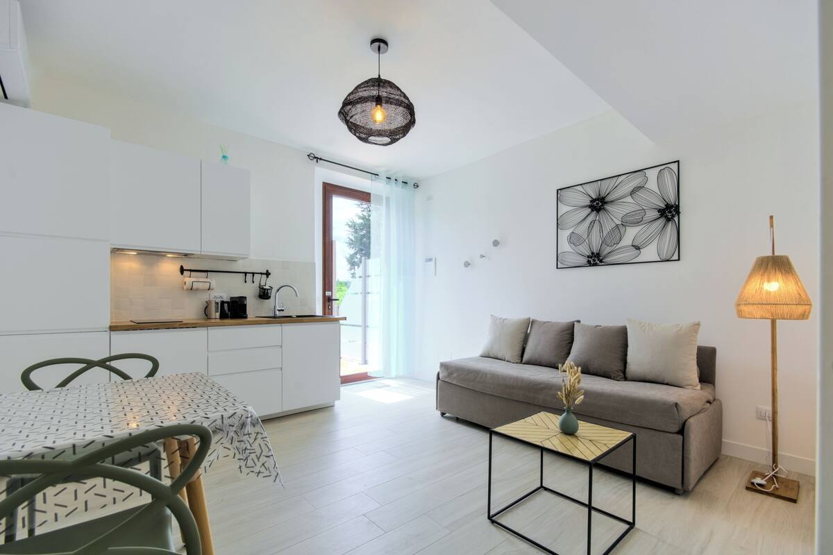 Un espacio moderno para vivir, con cocina, comedor y sofá.