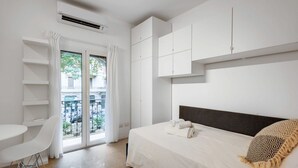 Un dormitorio moderno con cama, escritorio y vistas al exterior.