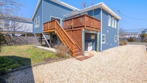 Une maison à deux étages avec un escalier en bois menant à une terrasse.