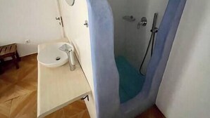 A bathroom with a shower, toilet, and sink.