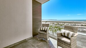 A balcony with wicker furniture and a view of the beach. - Modern Beachfront Retreat 2 King Suites + (Puerto Peñasco)