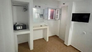 A small, compact bathroom with a white sink, a mirror, and a towel rack. - Two-room apartment for 4 people, with (Mikonos)