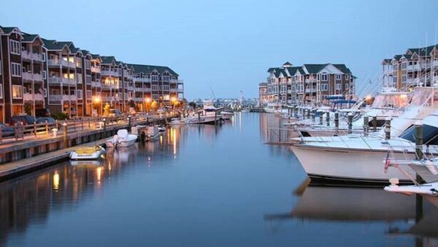 A marina with docked boats and waterfront buildings.