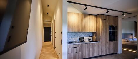 A modern kitchen with wooden cabinets, a marble countertop, and built-in appliances.