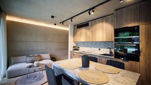 A modern kitchen with a central island, built-in appliances, and a dining area with a sofa and coffee table.