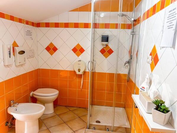 A bathroom with a shower, toilet, bidet, and a sink. - lastminute (Ferrara)