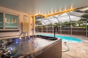 Boblebad med gennemsigtigt tag, pool og overdækket terrasse.