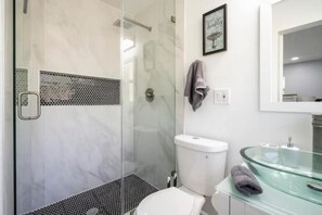 Chuveiro, secador de cabelo, toalhas de banho, sabonete