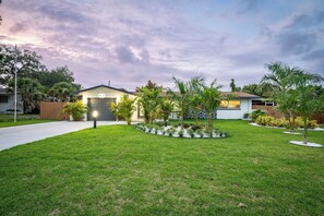 Il s’agit d’une propriété résidentielle dotée d’une pelouse bien entretenue, d’un garage et d’un petit jardin agrémenté de diverses plantes.