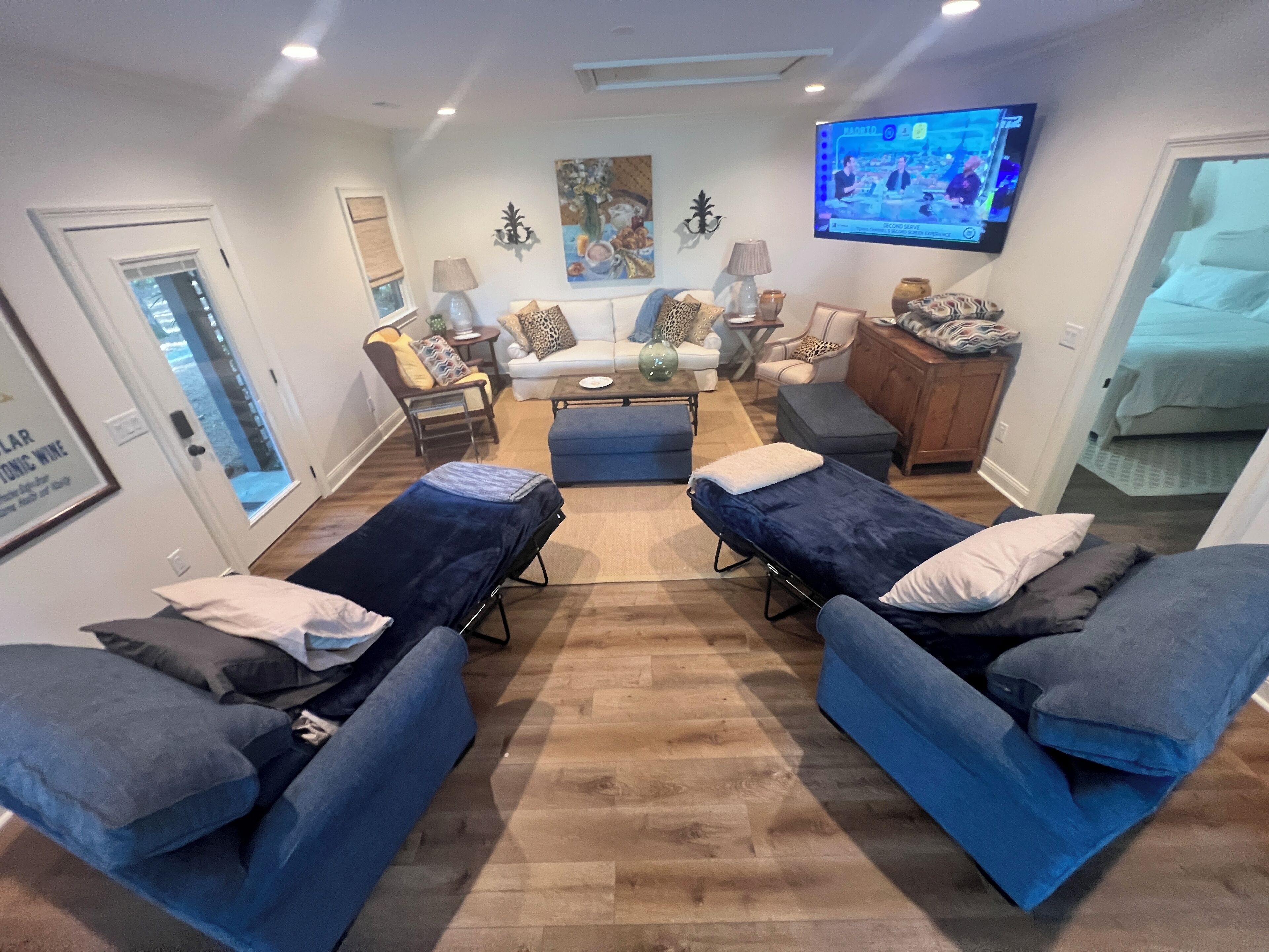 A modern living room with a sofa set, a coffee table, and a television mounted on the wall.