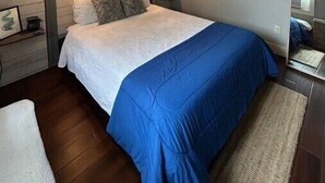 Ein Schlafzimmer mit einem Bett, einem Deckenventilator, Wandleuchten, einer herzförmigen Dekoration und einer Lichterkette.