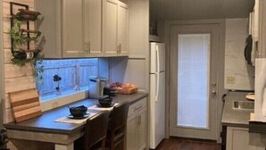 Eine Küche mit Holzausstattung, einer zentralen Kochinsel, einem Deckenventilator und einem Kühlschrank.