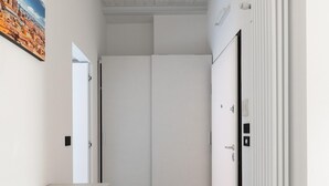 A hallway with a white door, a radiator, and a picture on the wall. - White Daisy Apartment by Wonderful Italy (Bologna)