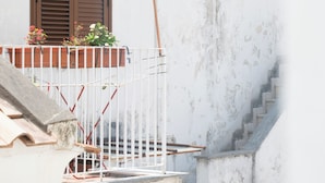 A building with a balcony, a flag, and a staircase. - Residenza Giuseppe (Amalfi)