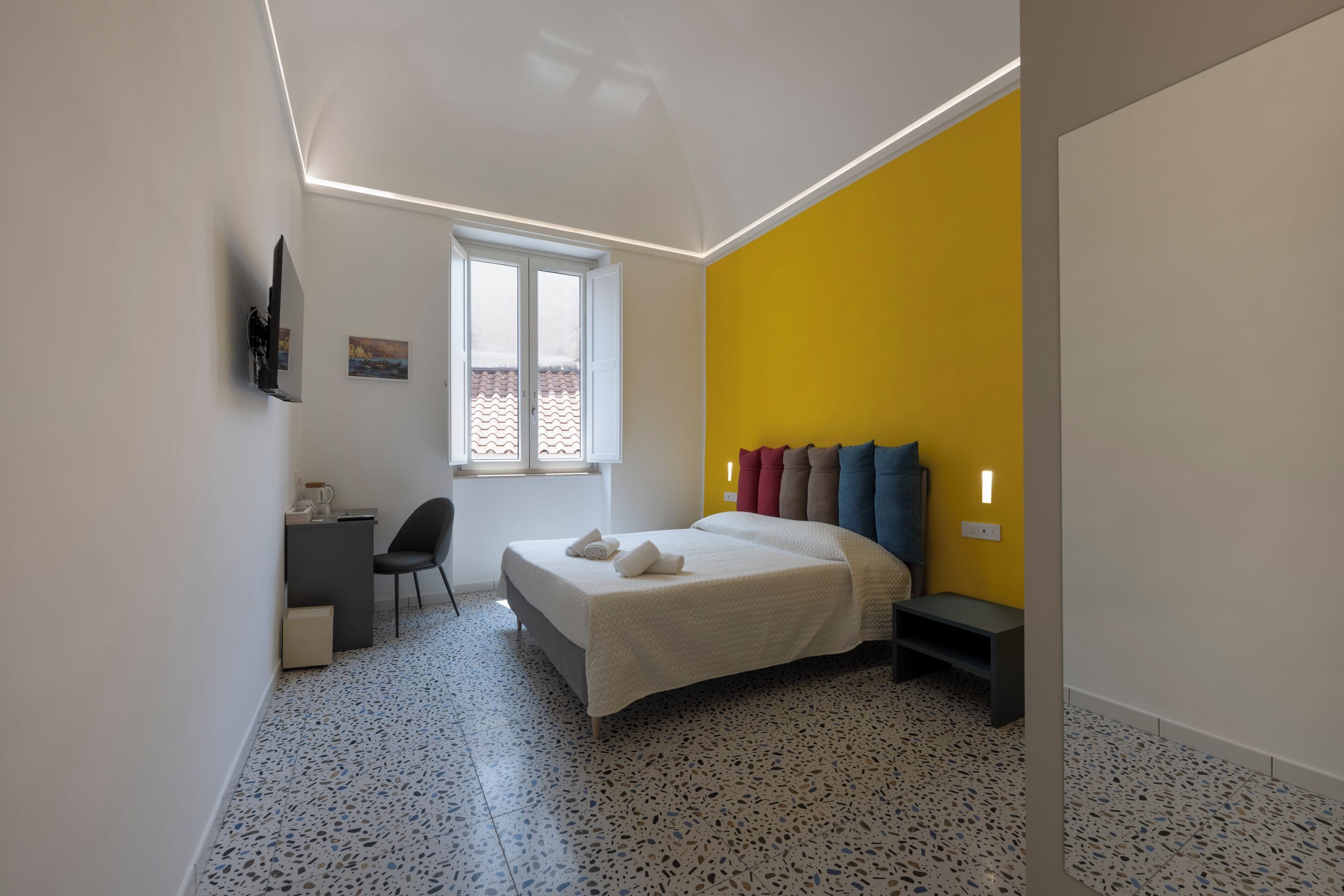 A modern bedroom with a bed, a desk, and a chair.