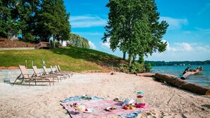 A beach picnic setup with a blanket, food, and chairs. - Beach-view Studio Cabin with Private Porch - #13 (Charlotte)