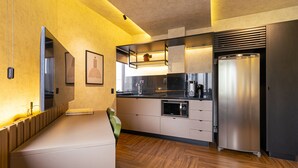 Una cocina moderna con microondas integrado, refrigerador de acero inoxidable y piso de madera.
