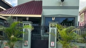 Un edificio con un ingresso chiuso da cancello, piante in vaso e un cartello che indica proprietà privata.