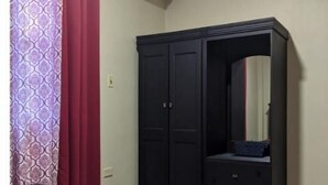 Una camera da letto con un letto, un armadio, uno specchio e un condizionatore d'aria.