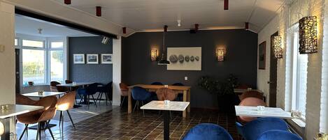 A restaurant interior with high ceilings, exposed brick walls, and a mix of modern and rustic decor.