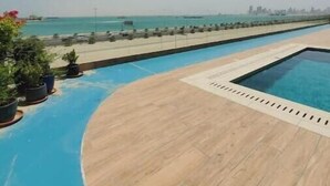 Un espace piscine offrant une vue sur la mer et le panorama urbain.