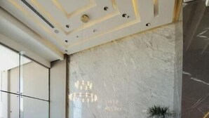 A modern lobby with a blue sofa, a coffee table, and a potted plant. - A luxurious sea view 2 bedrooms apartment (Al HIDD)