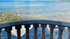 A clear view of a tropical beach with a stone balustrade in the foreground. - Oceanfront South Sound Home with Magical Sunsets! (Patricks Island)