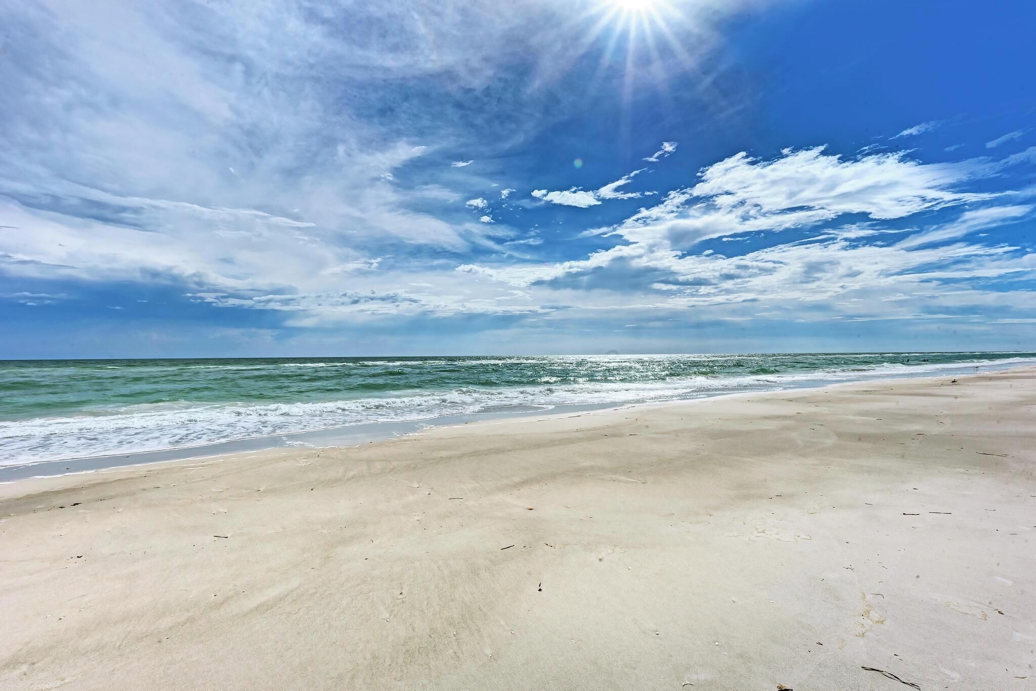 Een strand met een heldere lucht en zonlicht.