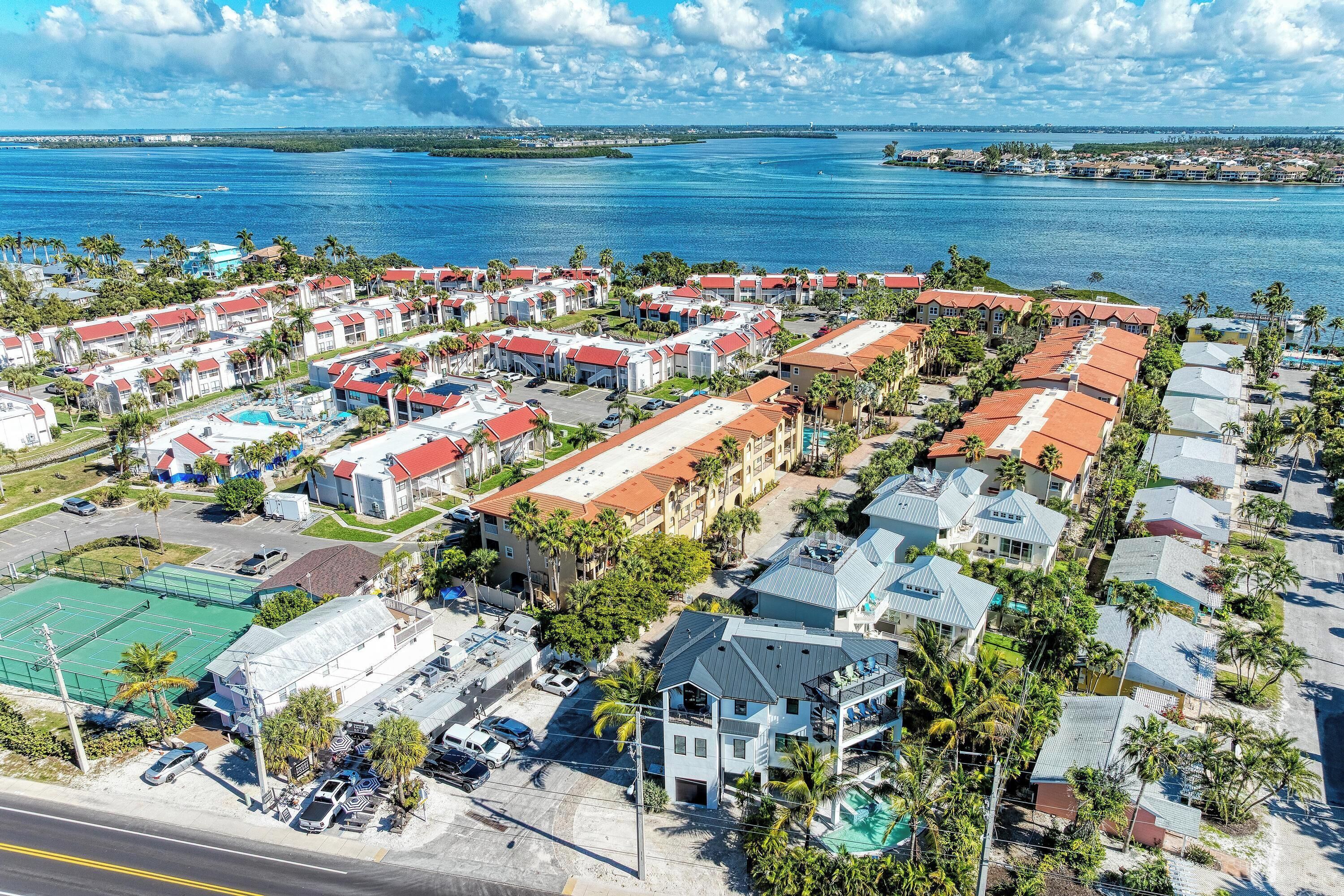 A coastal residential area with multiple buildings, a clear view of the ocean, and a parking lot.