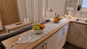 Una cocina moderna con encimera de madera, un bol de fruta y una cafetera.