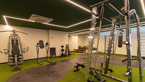 A gym with various exercise equipment, a green carpeted floor, and a mirror wall. - Vossa Bossa Moema ON (São Paulo)
