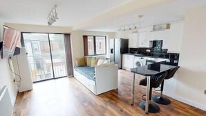 A compact living space with a kitchenette, a dining area, and a sofa. - Lovely two bed flat with free parking (Nottingham)