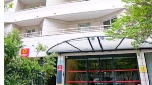 A multi-story building with a modern architectural design, featuring balconies on each floor and a covered entrance area. - Charming apartment with terrace, near Paris (Courbevoie)