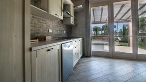 A modern kitchen with a stone backsplash, wooden cabinets, and a built-in dishwasher. - Fattoria Palazzeta Pet & Family Friendly (Cecina)