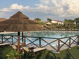 Una piscina al aire libre de temporada, sombrillas