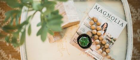A white tray with a magazine titled 'The Magnolia Journal', a small potted plant, and some decorative items.