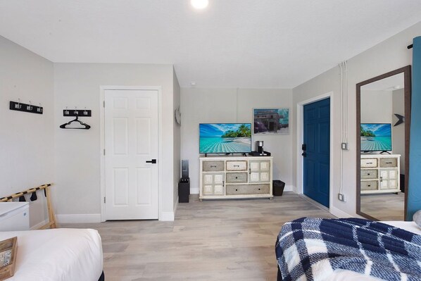Un dormitorio con cama, cómoda, televisor y armario.