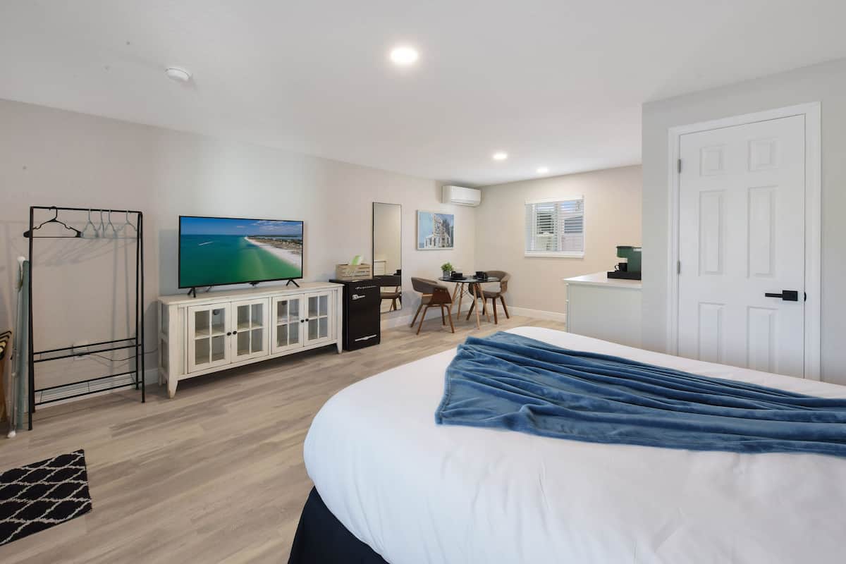 Une chambre d’hôtel avec un grand lit, une télévision, un bureau et une chaise.