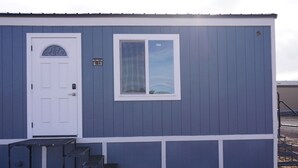 A single-story building with a white door and a window with a view of the sky. - 068A Cozy Studio Grand Canyon South Rim Sleeps-2 (Williams)