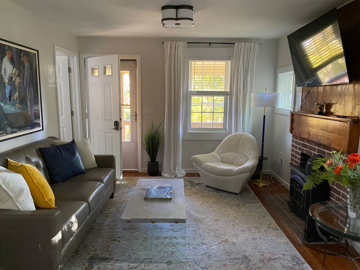A living room with a sofa, armchair, coffee table, and a fireplace.