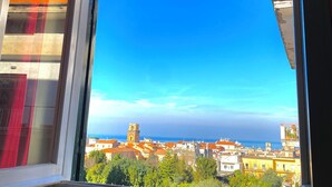 A window with a view of a coastal cityscape, including buildings and a clear blue sky. - Casa Mar - Apartment with Pool and Panoramic Terrace in the Heart of Sorrento (Sorrento)