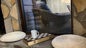 A stone fireplace with a woven rug and a chessboard with a mug. - Newly Renovated Townhome near Marietta Square, 2 King Beds (Marietta)