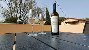 Une bouteille de vin et deux verres sur une table à l’extérieur.