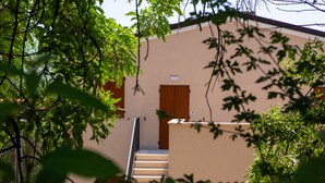Un escalier menant à une porte, avec un mur de couleur beige et une porte marron.